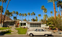 1950s car parked outside a mid-century modernism design house on a sunny, blue-sky day in Palm Springs, California, US.