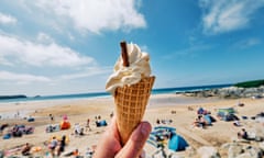 POV wide angle view of a hand holding Ice cream cone at Fistral Beach, Newquay on a sunny June day.