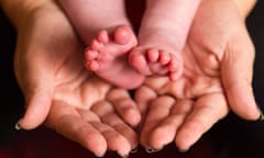 A mother holding the feet of a new baby. 