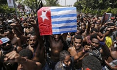 A Papuan activist holds up a separatist 'Morning Star' flag during a rally near the presidential palace in Jakarta, Indonesia, Thursday, Aug. 22, 2019. A group of West Papuan students in Indonesia's capital staged the protest against racism and called for independence for their region. (AP Photo/Dita Alangkara)