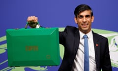A youngish south Asian man holds a green briefcase up to the camera