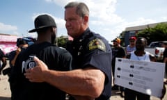 A Dallas police officer hugs a man following a prayer circle after a Black Lives Matter protest following the multiple police shootings in Dallas, Texas, U.S., July 10, 2016.  REUTERS/Carlo Allegri     TPX IMAGES OF THE DAY