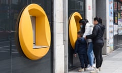 People withdraw money at an ATM in Madrid