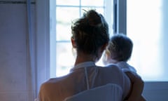 Rear view of mid adult woman and baby daughter looking out of living room window