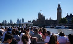 Tourists take a riverside cruise on the Thames.