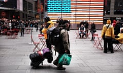 A man walks through New York City’s Times Square with his belongings