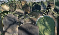 A collection of moss-covered headstones in a country churchyard.