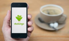 A man looks at his iPhone which displays the Duolingo logo (Editorial use only).<br>R76AC1 A man looks at his iPhone which displays the Duolingo logo (Editorial use only).