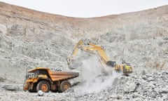 An excavator clears out rocks into a dumper at a gold mine