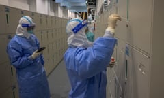 Workers wearing protective gear examine journalists' lockers for Covid-19 traces at the Olympic main media centre in Beijing.