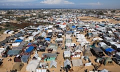 Displaced Palestinian, who fled their houses due to Israeli strikes, take shelter in a tent camp in Rafah on February 14, 2024