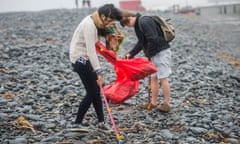 Young university students volunteering to clean litter off the beach and foreshore at Aberystwyth Wales UK.<br>DXA00K Young university students volunteering to clean litter off the beach and foreshore at Aberystwyth Wales UK.