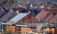 New houses on a construction site with scaffolding surrounding the properties