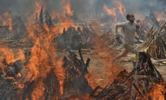 A man runs to escape heat emitting from the multiple funeral pyres of COVID-19 victims at a crematorium in the outskirts of New Delhi, India, Thursday, April 29, 2021. (AP Photo/Amit Sharma)