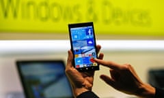 A Microsoft representative shows a smartphone with Windows 10 operating system at the CeBIT trade fair in Hanover in this file photo<br>A Microsoft representative shows a smartphone with Windows 10 operating system at the CeBIT trade fair in Hanover, Germany in this file photo from March 15, 2015. Microsoft recently announced a variety of ways to make it easier for developers to turn their Android or Apple app into a Windows app, in the hope that it will make its relatively unpopular Windows mobile devices more attractive and relevant. REUTERS/Morris Mac Matzen/Files