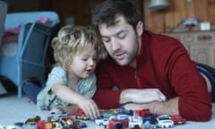 Father and toddler daughter playing with toy cars in sitting room<br>TITLE