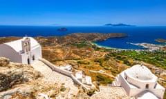 A white-painted church on top of a hill on the Greek island of Serifos, with a bay seen far below