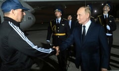 Krasikov shakes the hand of Putin while Russian guards stand in the background