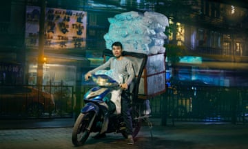 A delivery driver on a motorbike in Hanoi, Vietnam, carrying ice for bars and restaurants