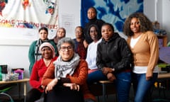 The seven women on the Ubuntu team sit and stand, with cloth decorations on the walls, and Fatou Gitteh and Dania Thomas on chairs in the front