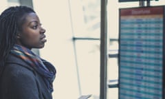 Young woman at airport checks the arrivals and departures board