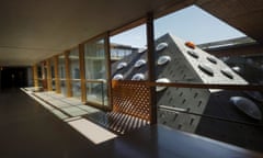 a pyramid-shaped roof next to a glass-sided corridor in herzog and de meuron's rehab clinic in basel