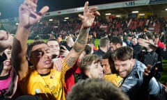 Delirious Alvechurch players and fans celebrate at the end of their win at Cheltenham.