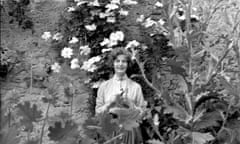 Duchess of Devonshire standing in garden surrounded by white flowers