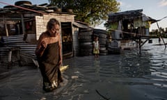 An elderly woman wades through sea water that flooded her village in Kiribati