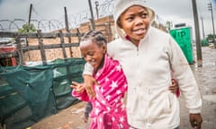 Two girls walk down a street in an impoverished area of Soweto.