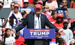 a man in a suit and a maga hat speaks