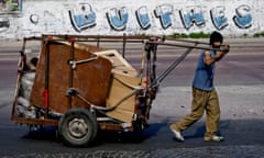 A trash recycler pushes his cart past a sign that reads “vultures” in reference to the dispute between the Argentine government and a U.S. hedge fund, known locally as “vulture funds,” in Buenos Aires, Argentina, Friday, Aug. 1, 2014. The full graffiti read “homeland or vultures.” The collapse of talks with U.S. creditors on July 30 sent Argentina into its second debt default in 13 years and raised questions about what comes next for financial markets and the South American nation’s staggering economy. (AP Photo/Victor R. Caivano)