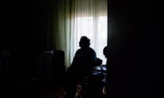 Silhouette of elderly woman alone in dark room.