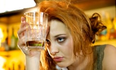 Young woman with a hangover holding her almost empty cocktail glass