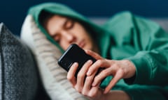 Teenager using phone while laying down on the sofa