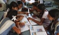 A group of school children in a classroom in India discuss their work