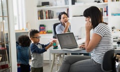 Parents working in home office with children playing