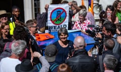 Sarah Finch is surrounded by the media and campaigners, some holding banners.