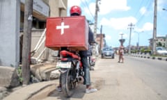 A moped carrying medical supplies is parked up on near the kerb on a road