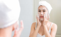 Woman Applying Face Wash In bathroom (Posed by model)