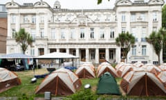 Tents on a lawn in front of university buildings