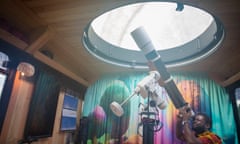 Kingsley Ahenkora-Duodu looks through a telescope in the converted school bus through a viewpoint in the roof