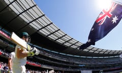 cricketers wielding bats are seen walking out before crowded stands at the MCG