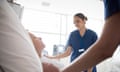 Medical staff looking after patient in hospital, close up<br>Female nurse and colleague caring for senior woman lying in hospital bed. Two medical staff assisting senior female patient