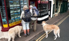 Couple with dogs looking in estate agent's window