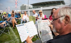 A racegoer studies the form ahead on Oaks day at Epsom.