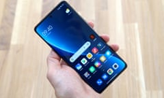 Xiaomi 12 Pro reviewed in the hand above a table