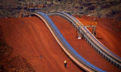 Worker walks near conveyer belts loaded with iron ore at the Fortescue Solomon iron ore mine located in the Valley of the Kings<br>A worker walks near conveyer belts loaded with iron ore at the Fortescue Solomon iron ore mine located in the Valley of the Kings, around 400 km (248 miles) south of Port Hedland in the Pilbara region of Western Australia December 2, 2013.. Picture taken December 2, 2013. REUTERS/David Gray