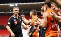 Leon Cameron leaves the field through a guard of honour after his last AFL match as coach of the GWS Giants.