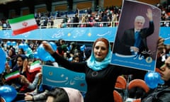 An Iranian supporter of the reformists holds a picture of parliamentary candidate Mohmmad Reza Aref.